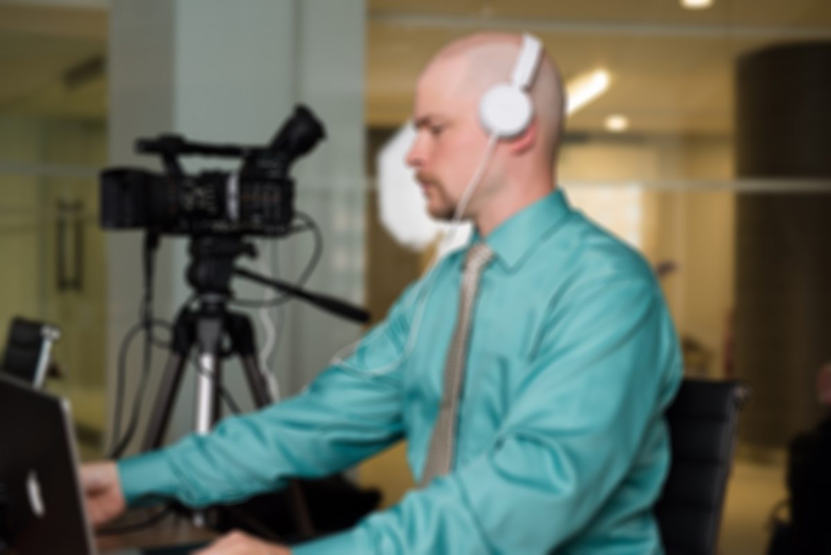 Daniel Holmstock operating camera and live mixing at a deposition